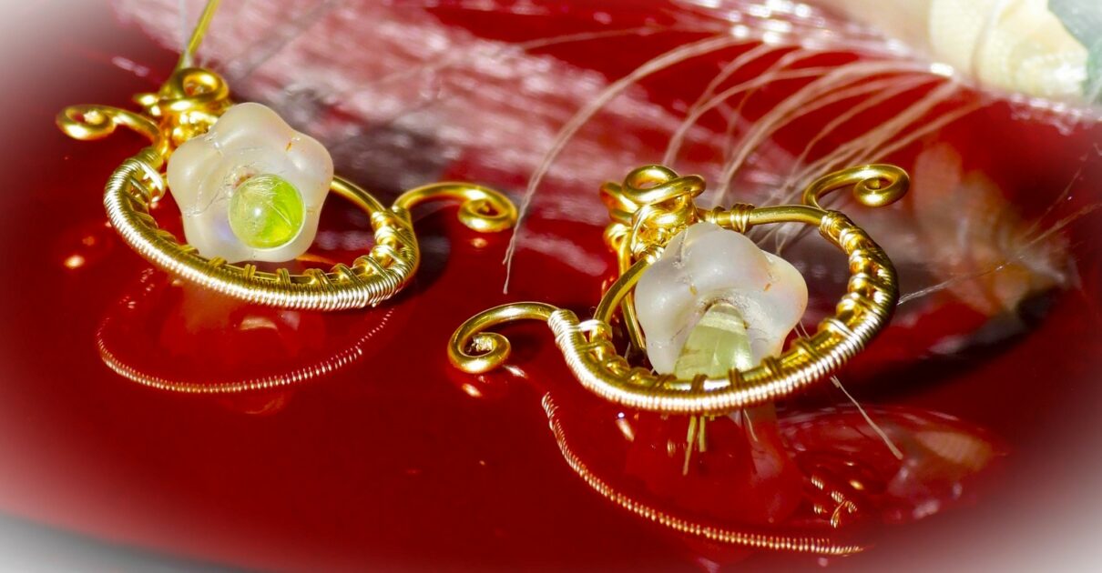 Boucles d'oreilles en fil de cuivre doré enroulé, de forme ronde. Une Perle goute en verre jaune suspendu à une perle en Christale mat au centre du bijoux